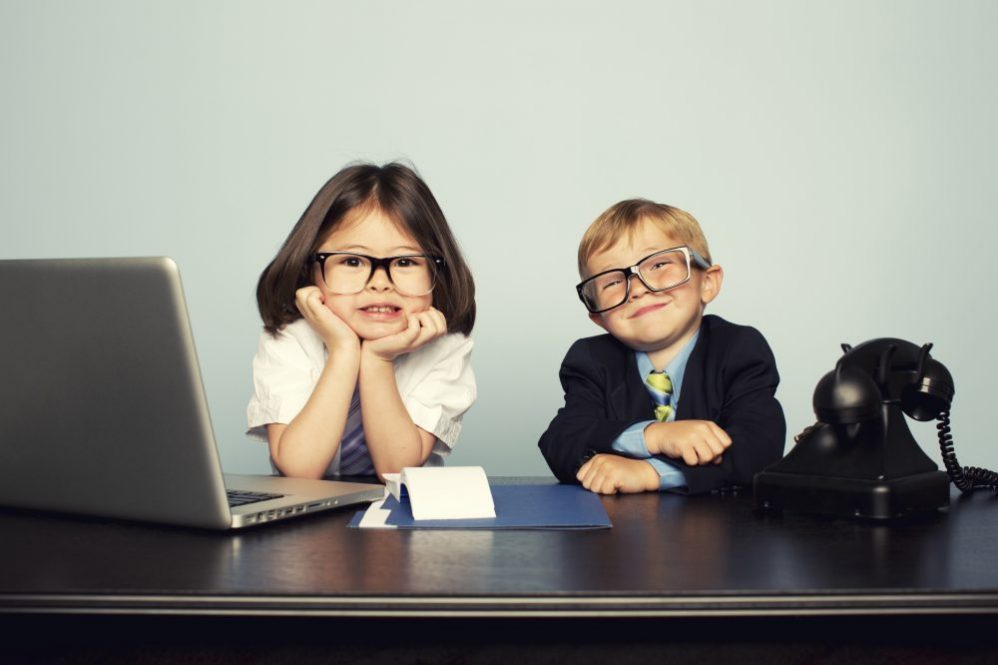 2 children, boy and girl, smiling in work attire